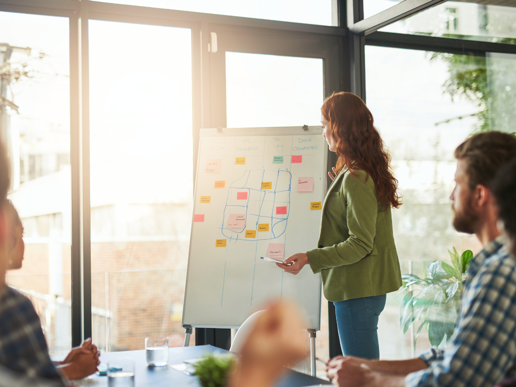 une femme présente une stratégie marketing dans une salle de réunion